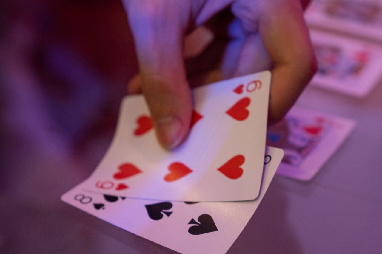 Hand holding playing cards in a close-up shot, capturing the game action.